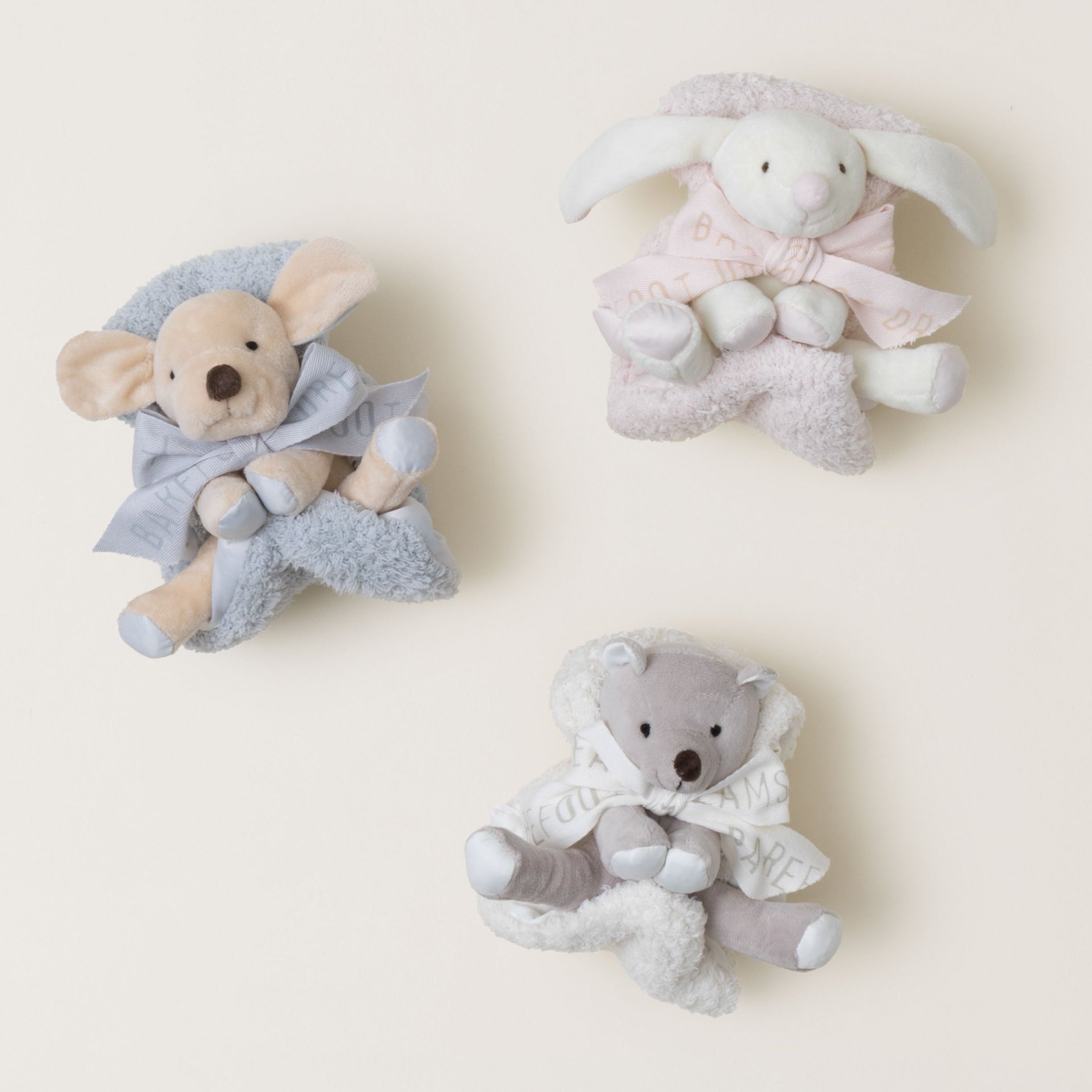 Three soft toy figures, including a bear, a rabbit, and a sheep, on a light beige background.